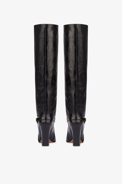 Tall, knee-high boots in shiny black vintage leather